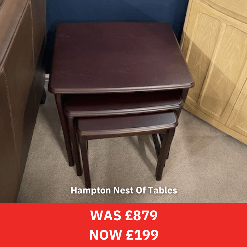 Set of three wooden tables with a price tag on a gray floor.