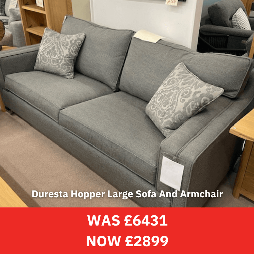 Gray Duresta sofa with patterned cushions in a room setting, with a price tag indicating a discount.